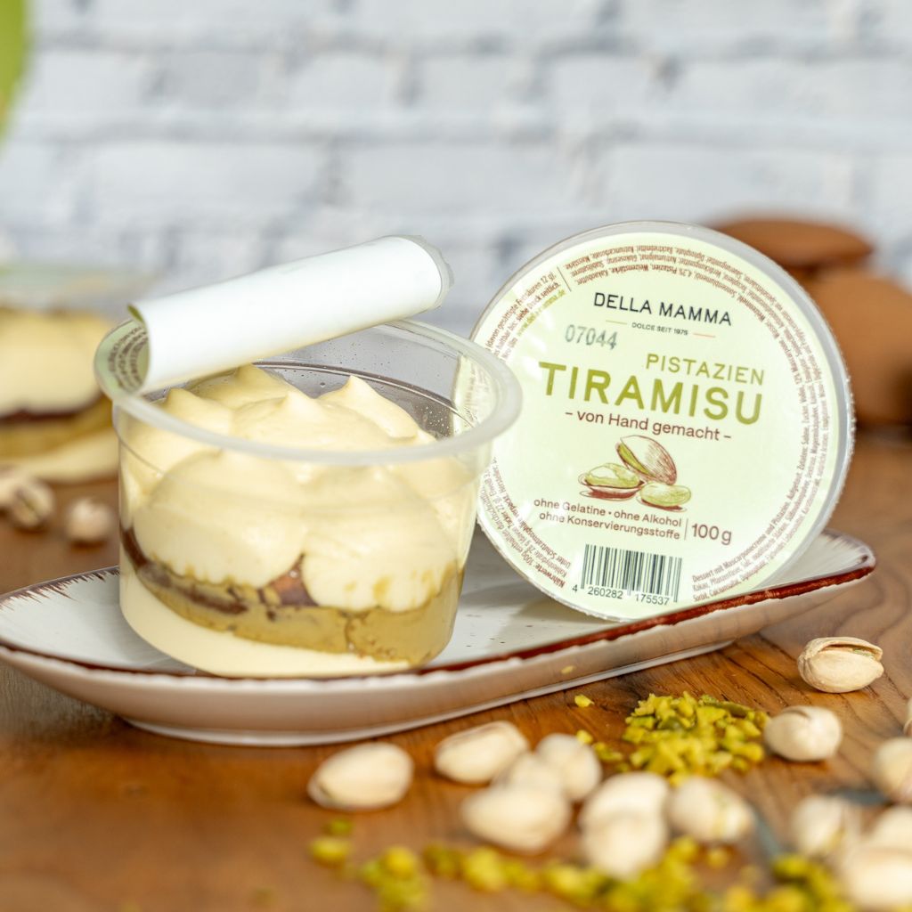 Im Vordergrund frische Pistazien und im Hintergrund das Pistazien Tiramisu