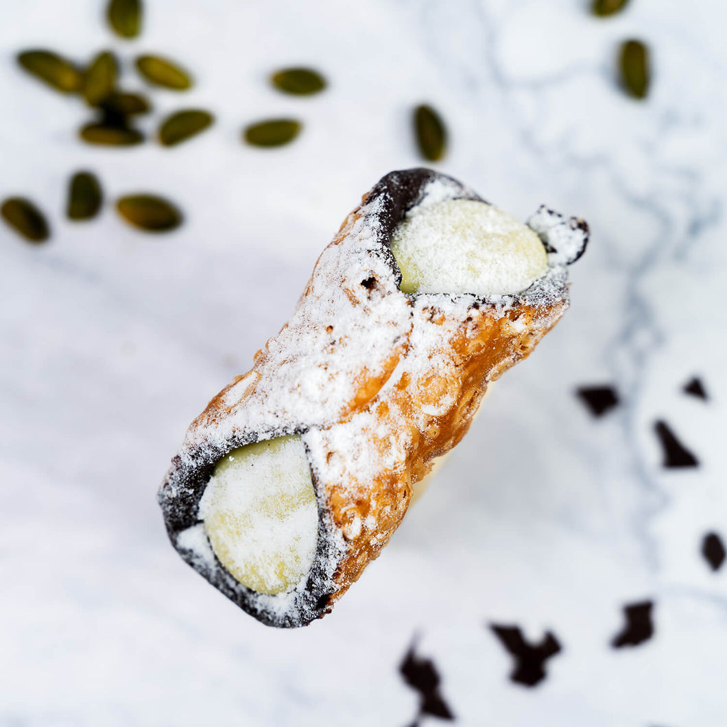 Pistazien Cannolo – Frittierte Mürbteigröllchen, innen mit Schokolade ausgestrichen, gefüllt mit Pistaziencreme und Puderzucker bestreut